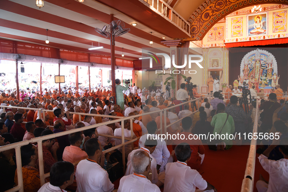 Devotees attend to watch a priest of the Ramakrishna Mission perform arati for a living goddess Kumari in front of a clay image of the Hindu...