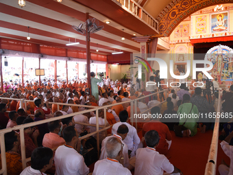 Devotees attend to watch a priest of the Ramakrishna Mission perform arati for a living goddess Kumari in front of a clay image of the Hindu...