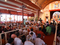 Devotees attend to watch a priest of the Ramakrishna Mission perform arati for a living goddess Kumari in front of a clay image of the Hindu...