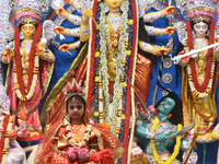 A priest of the Ramakrishna Mission performs a ritual for a living goddess Kumari in front of a clay image of the Hindu goddess Durga during...