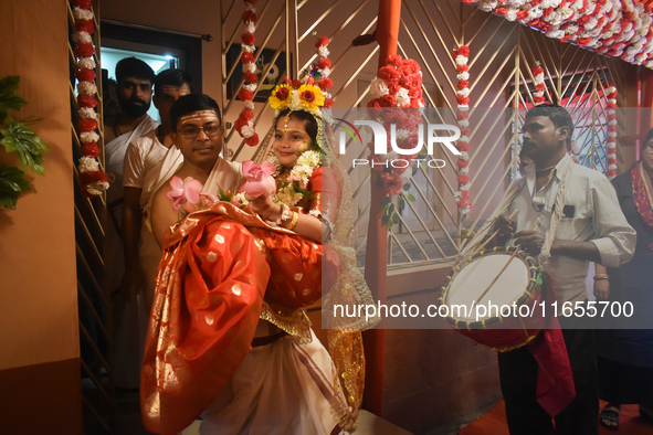 Esha Chatterjee, an eight-year-old girl dressed as a Kumari, is carried by a priest during the religious festival of Durga Puja in Kolkata,...