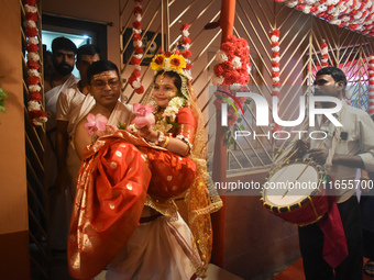 Esha Chatterjee, an eight-year-old girl dressed as a Kumari, is carried by a priest during the religious festival of Durga Puja in Kolkata,...