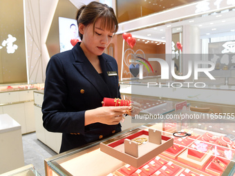 A staff member arranges gold ornaments at a gold shop in Renhuai, China, on October 11, 2024. (