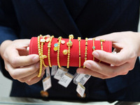 A staff member arranges gold ornaments at a gold shop in Renhuai, China, on October 11, 2024. (