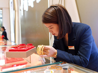 A staff member arranges gold ornaments at a gold shop in Renhuai, China, on October 11, 2024. (