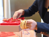 A staff member arranges gold ornaments at a gold shop in Renhuai, China, on October 11, 2024. (