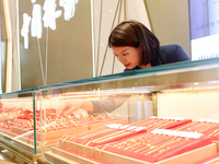 A staff member arranges gold ornaments at a gold shop in Renhuai, China, on October 11, 2024. (