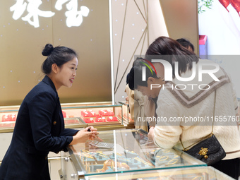 Consumers shop for gold jewelry at a gold store in Renhuai, China, on October 11, 2024. (