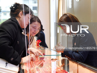 Consumers shop for gold jewelry at a gold store in Renhuai, China, on October 11, 2024. (