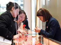 Consumers shop for gold jewelry at a gold store in Renhuai, China, on October 11, 2024. (