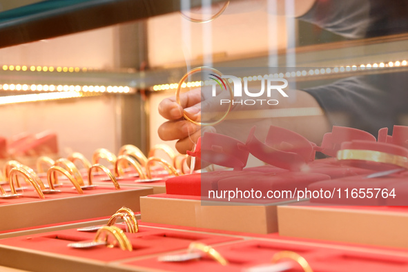 A staff member arranges gold ornaments at a gold shop in Renhuai, China, on October 11, 2024. 