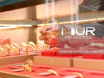 A staff member arranges gold ornaments at a gold shop in Renhuai, China, on October 11, 2024. (