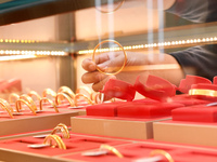 A staff member arranges gold ornaments at a gold shop in Renhuai, China, on October 11, 2024. (