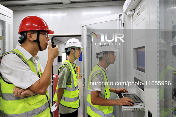 Technicians perform grid-connected power supply operations in a computer room in Liuzhou, China, on October 10, 2024. 