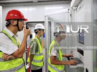 Technicians perform grid-connected power supply operations in a computer room in Liuzhou, China, on October 10, 2024. (