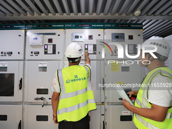 Technicians perform grid-connected power supply operations in a computer room in Liuzhou, China, on October 10, 2024. (