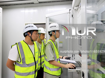 Technicians perform grid-connected power supply operations in a computer room in Liuzhou, China, on October 10, 2024. (