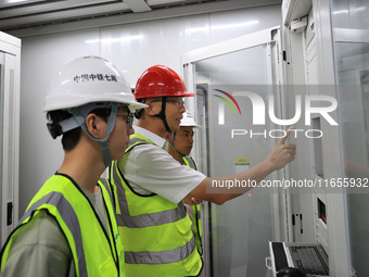 Technicians perform grid-connected power supply operations in a computer room in Liuzhou, China, on October 10, 2024. (