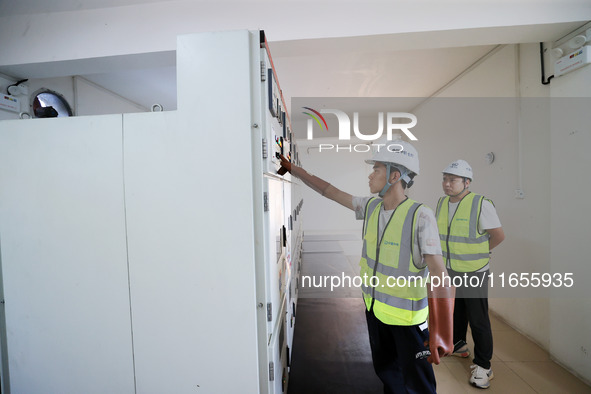 Technicians perform grid-connected power supply operations in a computer room in Liuzhou, China, on October 10, 2024. 