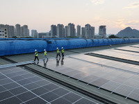 Technicians check photovoltaic power generation equipment before it is connected to the grid for power supply in Liuzhou, China, on October...