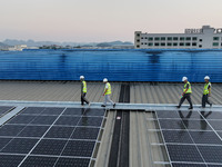 Technicians check photovoltaic power generation equipment before it is connected to the grid for power supply in Liuzhou, China, on October...