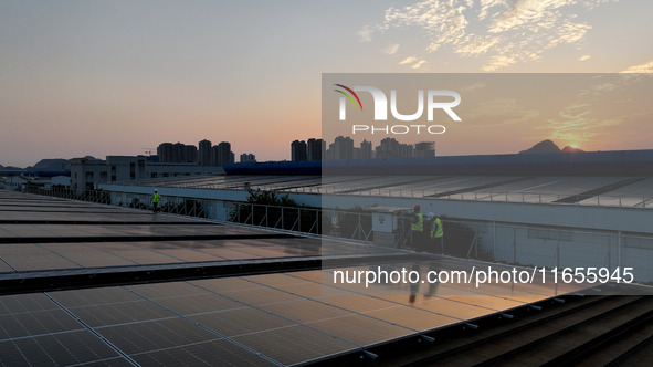 Technicians check photovoltaic power generation equipment before it is connected to the grid for power supply in Liuzhou, China, on October...