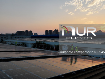 Technicians check photovoltaic power generation equipment before it is connected to the grid for power supply in Liuzhou, China, on October...