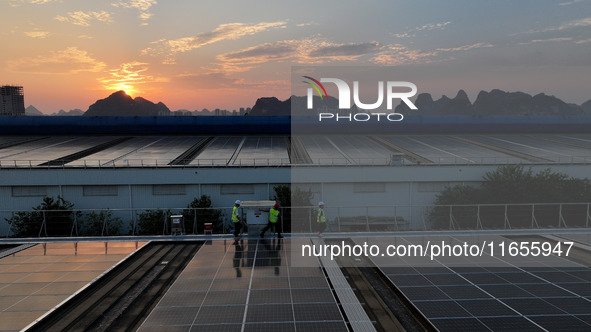 Technicians check photovoltaic power generation equipment before it is connected to the grid for power supply in Liuzhou, China, on October...