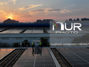 Technicians check photovoltaic power generation equipment before it is connected to the grid for power supply in Liuzhou, China, on October...