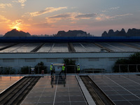 Technicians check photovoltaic power generation equipment before it is connected to the grid for power supply in Liuzhou, China, on October...