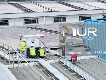 Technicians check photovoltaic power generation equipment before it is connected to the grid for power supply in Liuzhou, China, on October...