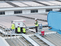 Technicians check photovoltaic power generation equipment before it is connected to the grid for power supply in Liuzhou, China, on October...