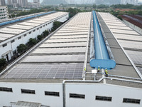 Technicians check photovoltaic power generation equipment before it is connected to the grid for power supply in Liuzhou, China, on October...