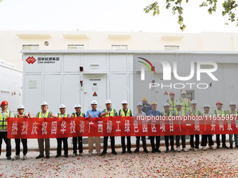 Engineers and technicians pose for a group photo after they successfully connect to the grid for power generation in Liuzhou, Guangxi Zhuang...