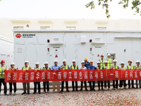 Engineers and technicians pose for a group photo after they successfully connect to the grid for power generation in Liuzhou, Guangxi Zhuang...