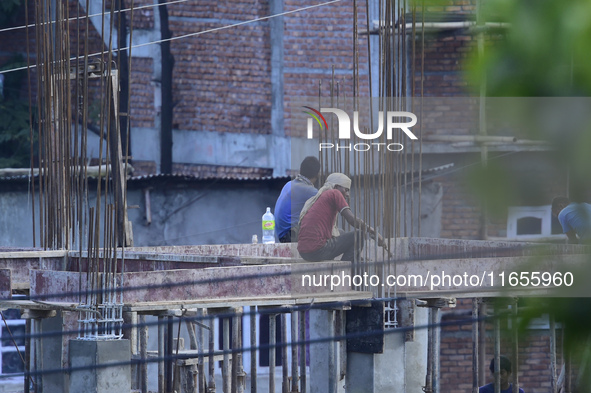 Workers work on a new building in Kirtipur, Kathmandu, Nepal, on October 7, 2024. 