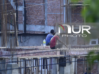 Workers work on a new building in Kirtipur, Kathmandu, Nepal, on October 7, 2024. (