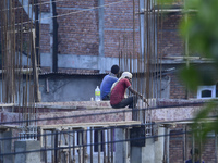 Workers work on a new building in Kirtipur, Kathmandu, Nepal, on October 7, 2024. (