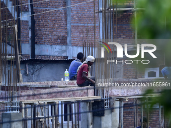 Workers work on a new building in Kirtipur, Kathmandu, Nepal, on October 7, 2024. (