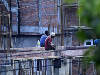 Workers work on a new building in Kirtipur, Kathmandu, Nepal, on October 7, 2024. (