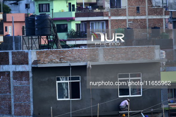 Workers work on a new building in Kirtipur, Kathmandu, Nepal, on October 7, 2024. 