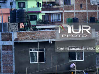 Workers work on a new building in Kirtipur, Kathmandu, Nepal, on October 7, 2024. (