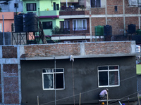 Workers work on a new building in Kirtipur, Kathmandu, Nepal, on October 7, 2024. (