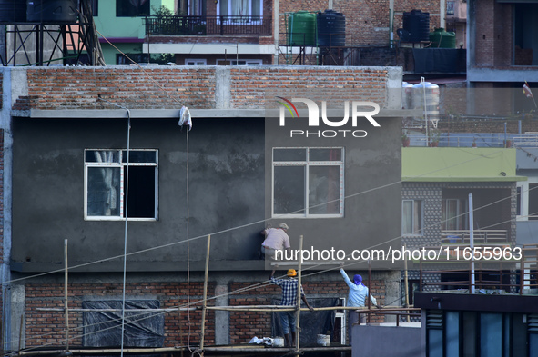 Workers work on a new building in Kirtipur, Kathmandu, Nepal, on October 7, 2024. 