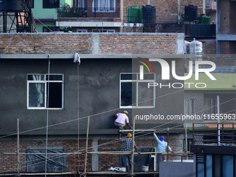 Workers work on a new building in Kirtipur, Kathmandu, Nepal, on October 7, 2024. (