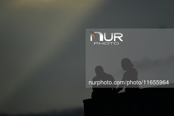 A silhouette of a couple enjoys the evening view in Kirtipur, Kathmandu, Nepal, on October 7, 2024. 