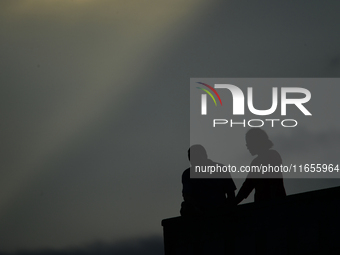 A silhouette of a couple enjoys the evening view in Kirtipur, Kathmandu, Nepal, on October 7, 2024. (