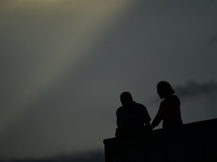 A silhouette of a couple enjoys the evening view in Kirtipur, Kathmandu, Nepal, on October 7, 2024. (