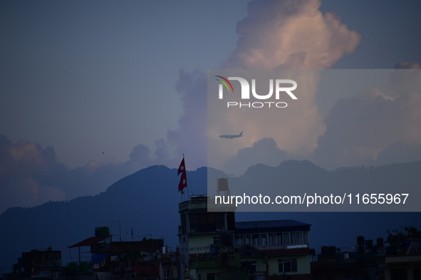 A Nepali domestic aircraft with passengers flies past a rainbow seen over the Nepali sky as it lands at Tribhuvan International Airport in K...