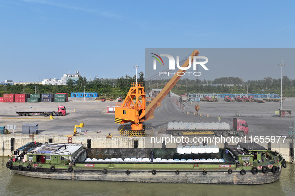 A crane transfers phthalic acid to a truck at the eastern operation area of Siyang Port on the Beijing-Hangzhou Grand Canal in Suqian, China...